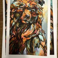 A "Song On The Wind" Limited Edition Print of a brown bear on a wooden table.