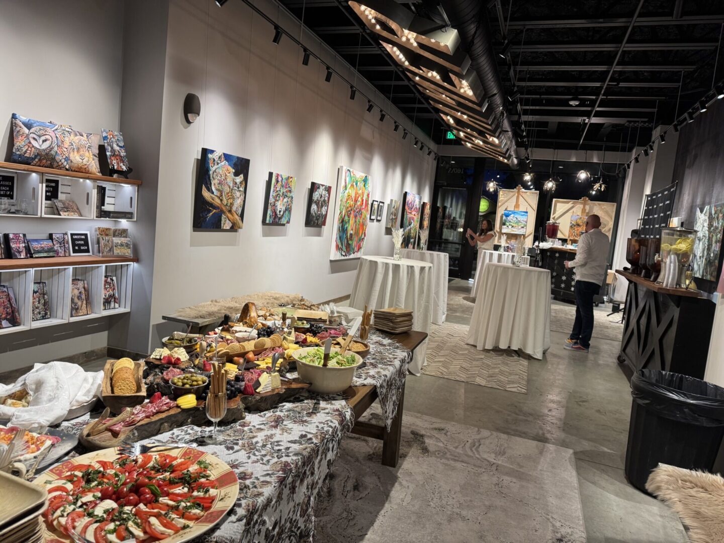 Art gallery reception with buffet and paintings