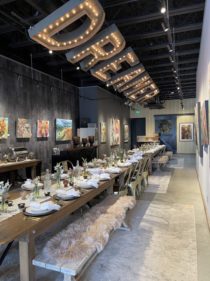 Long rustic dining table under marquee lights
