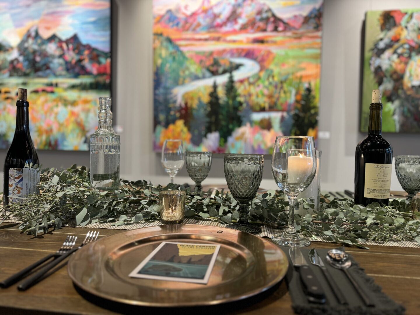 Table set with wine, glasses, greenery