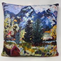 Pillow with painted mountains, trees, and horses